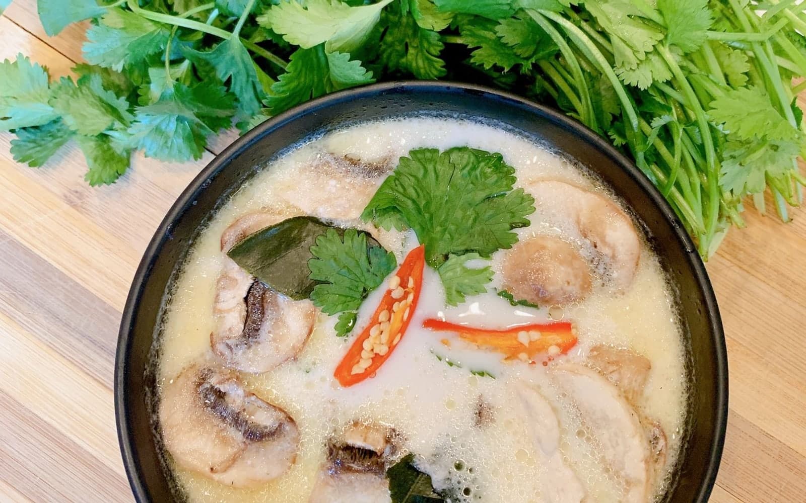 A bowl of coconut soup with mushrooms, chilli and fresh cilantro from Bowl on the Geaux